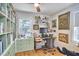 Organized home office with built-in shelves, a desk, and a window overlooking the greenery outside at 216 Northwood Cir, Durham, NC 27701