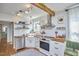 Bright kitchen with stainless steel appliances, butcher block countertops, white cabinets, subway tile backsplash, and wood beam at 216 Northwood Cir, Durham, NC 27701