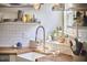 Kitchen sink with butcher block countertops, white subway tile, open shelving, and a window bringing in natural light at 216 Northwood Cir, Durham, NC 27701