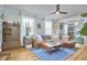 Inviting living room features a large leather couch, modern ceiling fan, and hardwood floors at 216 Northwood Cir, Durham, NC 27701