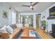 Bright living room features a fireplace, large leather couch, modern fan, and hardwood floors at 216 Northwood Cir, Durham, NC 27701