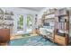 Bright office with shelves, computer and desk, and access to a garden area through French doors at 216 Northwood Cir, Durham, NC 27701