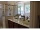 Bright bathroom features a double vanity, tiled shower, and a large mirror at 221 Grantwood Dr, Holly Springs, NC 27540