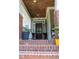 Inviting front porch with brick steps, decorative plants, and a stylish front door at 221 Grantwood Dr, Holly Springs, NC 27540