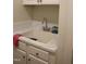 Practical laundry sink area with white cabinets, ample counter space, and good lighting at 221 Grantwood Dr, Holly Springs, NC 27540