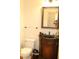 Charming powder room featuring vanity with granite countertop, decorative mirror, and ceramic toilet at 221 Grantwood Dr, Holly Springs, NC 27540