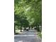 Street view with lush green trees lining the road, providing a serene and shaded environment at 221 Grantwood Dr, Holly Springs, NC 27540