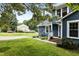 Exterior view of a blue home with well-manicured lawn, garden and brick steps to the front door at 2214 Pathway Dr, Chapel Hill, NC 27516
