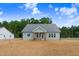 Charming single-story home showcasing light-colored siding, a covered porch, and a well-manicured front yard at 222 Cherrybirch Ln, Zebulon, NC 27597