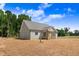 View of the back of this charming single-Gathering home with light gray siding, covered patio and lush green trees at 222 Cherrybirch Ln, Zebulon, NC 27597