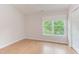 Bright bedroom featuring natural light from a large window and light, wood-look flooring at 2222 Pathway Dr, Chapel Hill, NC 27516