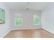 Bright, empty bedroom with hardwood floors, closet and two windows at 2222 Pathway Dr, Chapel Hill, NC 27516