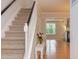 Bright foyer with staircase featuring carpeted stairs and a view into the living room at 2222 Pathway Dr, Chapel Hill, NC 27516