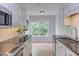Well-lit kitchen features white cabinets, granite countertops, and a window with a view at 2222 Pathway Dr, Chapel Hill, NC 27516