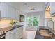 Well-lit kitchen features white cabinets, granite countertops, and a window with a view at 2222 Pathway Dr, Chapel Hill, NC 27516