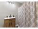 Well-lit bathroom featuring a wooden vanity and a shower with decorative curtain at 224 Grameta Ln, Lillington, NC 27546