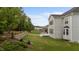Backyard view featuring a stone retaining wall, green lawn, and a spacious deck at 228 Cloverdale Rd, Apex, NC 27523