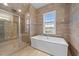 Elegant bathroom featuring a soaking tub, glass shower and a window for natural light at 228 Cloverdale Rd, Apex, NC 27523
