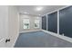 Bedroom featuring paneled accent wall, carpeted floors, and natural light from two windows at 228 Cloverdale Rd, Apex, NC 27523