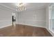 Bright dining room featuring hardwood floors, modern chandelier, and decorative wall sconces at 228 Cloverdale Rd, Apex, NC 27523