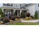 Charming home exterior with stone accents, manicured landscaping, and covered front porch entrance at 228 Cloverdale Rd, Apex, NC 27523