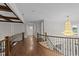 Elegant hallway featuring hardwood floors, decorative railings, and a stunning chandelier at 228 Cloverdale Rd, Apex, NC 27523