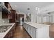 Well-lit kitchen featuring large island with seating, stainless steel appliances, and adjacent stairwell at 228 Cloverdale Rd, Apex, NC 27523