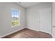 Bedroom with wood-look flooring featuring a window and a door at 236 Katie Dr, Rocky Mount, NC 27803