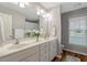 Bright bathroom features a dual sink vanity, large mirror, and wood-look flooring at 240 Carrington Ave, Franklinton, NC 27525