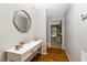 Charming entryway features hardwood floors, a white console table, and a decorative round mirror at 240 Carrington Ave, Franklinton, NC 27525