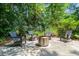 Backyard features a stone patio and fire pit, surrounded by mature trees and comfortable seating at 2504 W Club Blvd, Durham, NC 27705