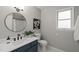 Chic bathroom with a dark blue vanity, round mirror, and modern fixtures, combining style and functionality at 2504 W Club Blvd, Durham, NC 27705