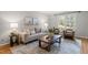 Comfortable living room featuring hardwood floors and neutral decor with bright light from a large window at 2504 W Club Blvd, Durham, NC 27705