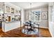 Sunlit dining area with hardwood floors, a round table, stylish light fixture, and adjacent kitchen features at 262 Salt Cedar Ln, Chapel Hill, NC 27516