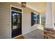 Stylish front door with glass panels, complemented by a cozy porch and stone-detailed column at 262 Salt Cedar Ln, Chapel Hill, NC 27516