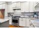 Close-up on the kitchen's stainless steel gas range, white cabinets, subway tile backsplash and granite countertops at 262 Salt Cedar Ln, Chapel Hill, NC 27516