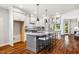 Bright, open kitchen features a large island with seating, stainless steel appliances, and beautiful hardwood floors at 262 Salt Cedar Ln, Chapel Hill, NC 27516