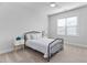 Neutral bedroom with carpeted floors, a ceiling fan, natural light, and a black metal bed frame at 2806 High Plains Dr, Fuquay Varina, NC 27526