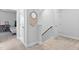 Hallway with carpet, white walls, wooden railing, and decorative macrame mirror hanging on the wall at 2806 High Plains Dr, Fuquay Varina, NC 27526