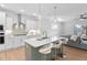 Modern kitchen with white cabinets, quartz countertops, large island, and pendant lighting at 2806 High Plains Dr, Fuquay Varina, NC 27526
