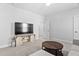 Living room with a large TV on a media console, a round coffee table, and a doorway at 2806 High Plains Dr, Fuquay Varina, NC 27526