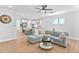 Bright living room with a modern sectional couch, ceiling fan, and open to kitchen with island seating at 2806 High Plains Dr, Fuquay Varina, NC 27526
