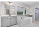 Luxurious bathroom featuring dual vanities, marble-tiled floors and a soaking tub at 2914 Farmhouse Dr, Apex, NC 27502