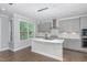 Well-lit kitchen with gray cabinets, center island, backsplash, and pendant lighting at 2914 Farmhouse Dr, Apex, NC 27502