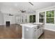 Open kitchen featuring center island with modern lighting overlooking living space and fireplace at 2914 Farmhouse Dr, Apex, NC 27502