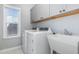 Laundry room featuring modern appliances, a utility sink, and ample cabinet space at 2914 Farmhouse Dr, Apex, NC 27502