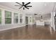 Open-concept living area with hardwood floors, ceiling fans, modern fixtures and backyard access at 2914 Farmhouse Dr, Apex, NC 27502