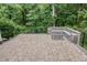 Paver patio with built in stone seating and firepit, surrounded by wooded area at 2914 Farmhouse Dr, Apex, NC 27502