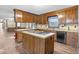 Kitchen features wood cabinets, a center island with cooktop, and durable laminate countertops at 3129 Tarheel Clubhouse Rd, Raleigh, NC 27604