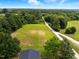 Expansive aerial view of the property showcasing lush greenery, mature trees, and a long driveway at 3129 Tarheel Clubhouse Road Rd, Raleigh, NC 27604